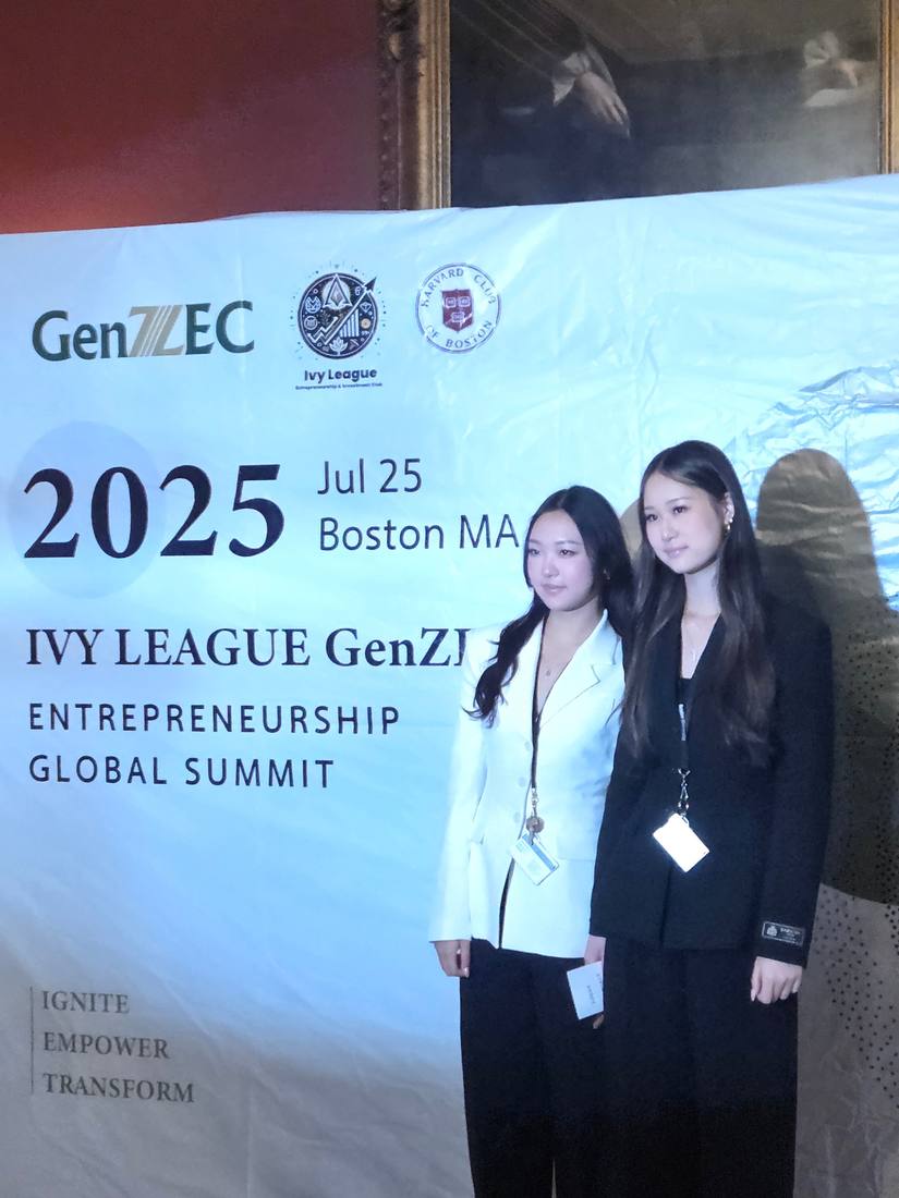 Two GenZec attendees standing in front of the 2025 entrepreneurship summit banner