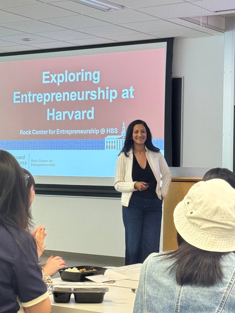 A presenter leading a session beneath a screen reading Exploring Entrepreneurship at Harvard