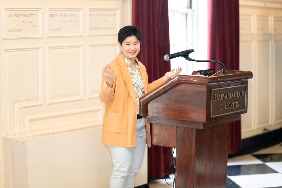 A presenter speaking at a podium during a GenZec summit session