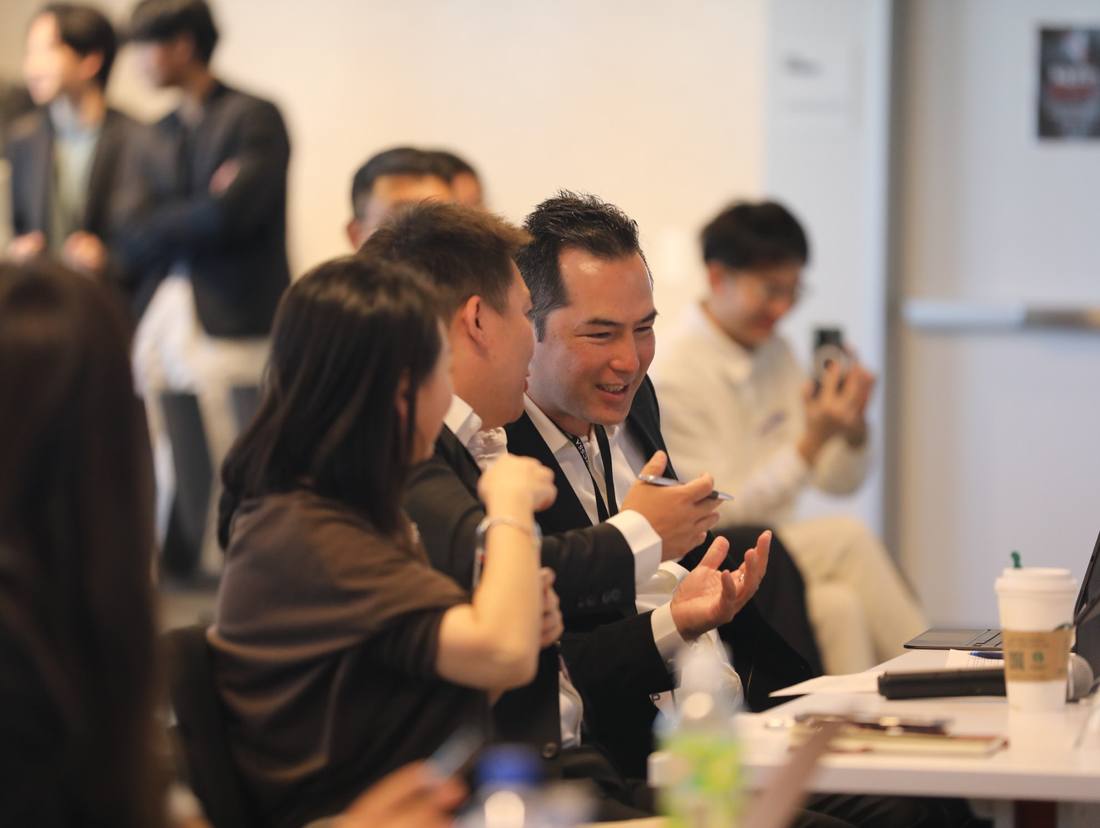 Participants exchanging ideas around a table during a program gathering
