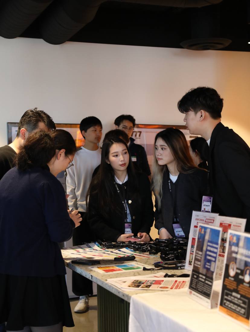 Participants and event staff gathered around a welcome table