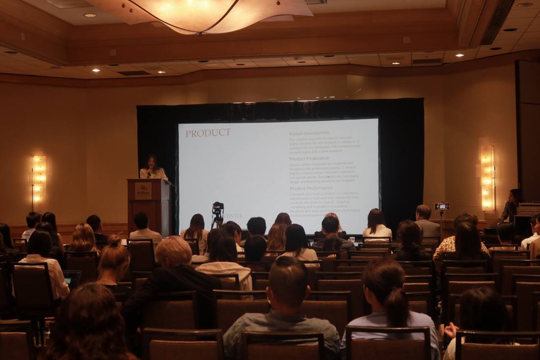 An audience facing a presentation at the 2024 competition