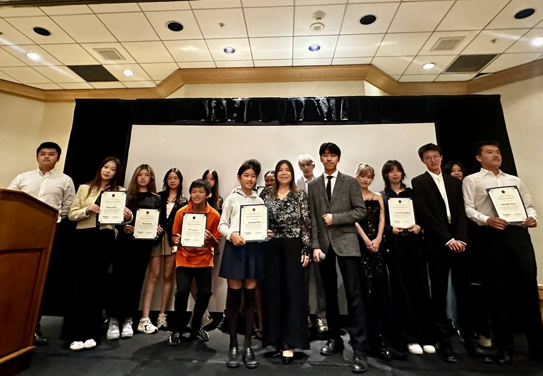 A group of participants holding certificates onstage at the 2024 competition
