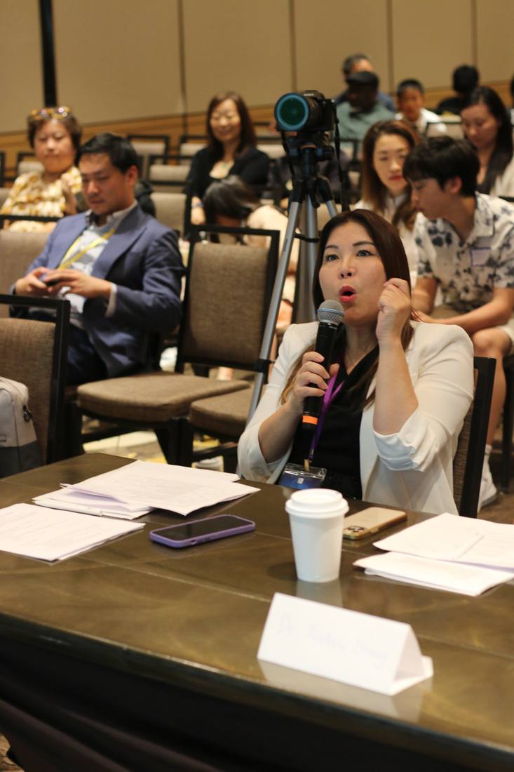 A seated attendee speaking into a microphone during the 2024 competition